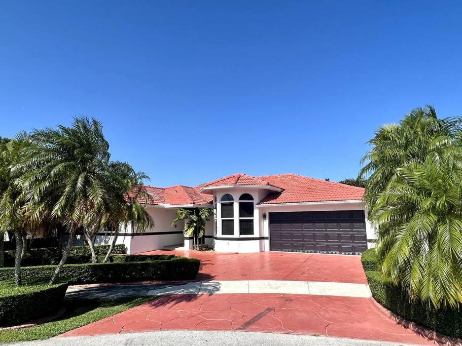 uma casa com palmeiras e uma entrada em Sunny Getaway: Relaxing Miami Home em Tamiami
