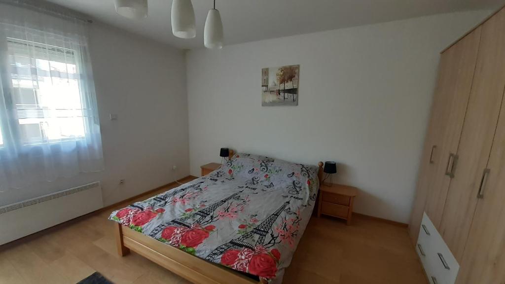 1 dormitorio con cama y ventana en APARTMAN AMSTERDAM en Brčko