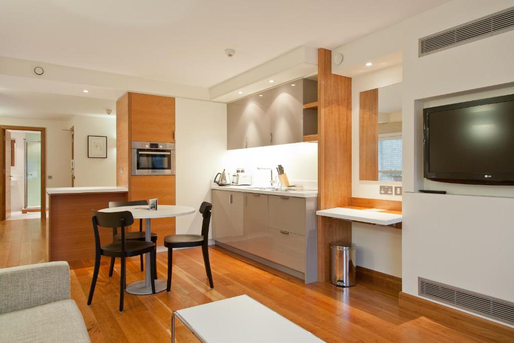 Il comprend une cuisine et un salon avec une table et des chaises. dans l'établissement Blueprint Living Apartments -Turnmill Street, à Londres