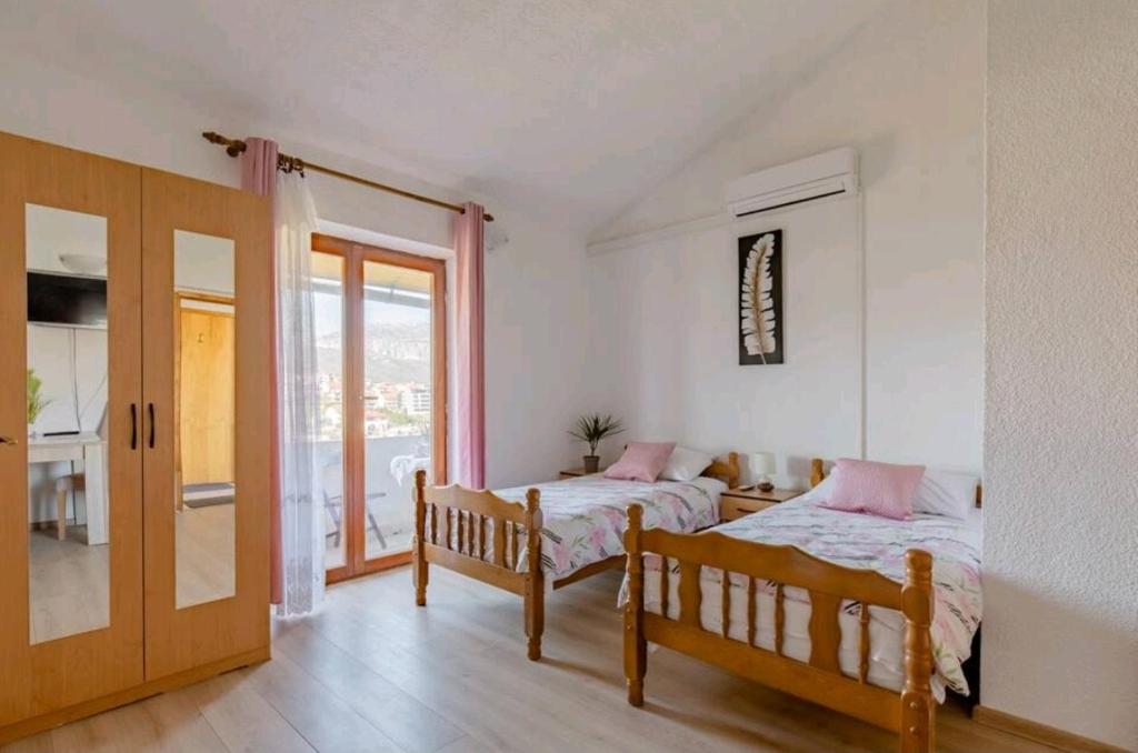1 dormitorio con 2 camas y puerta corredera de cristal en Apartmani Račić, en Split