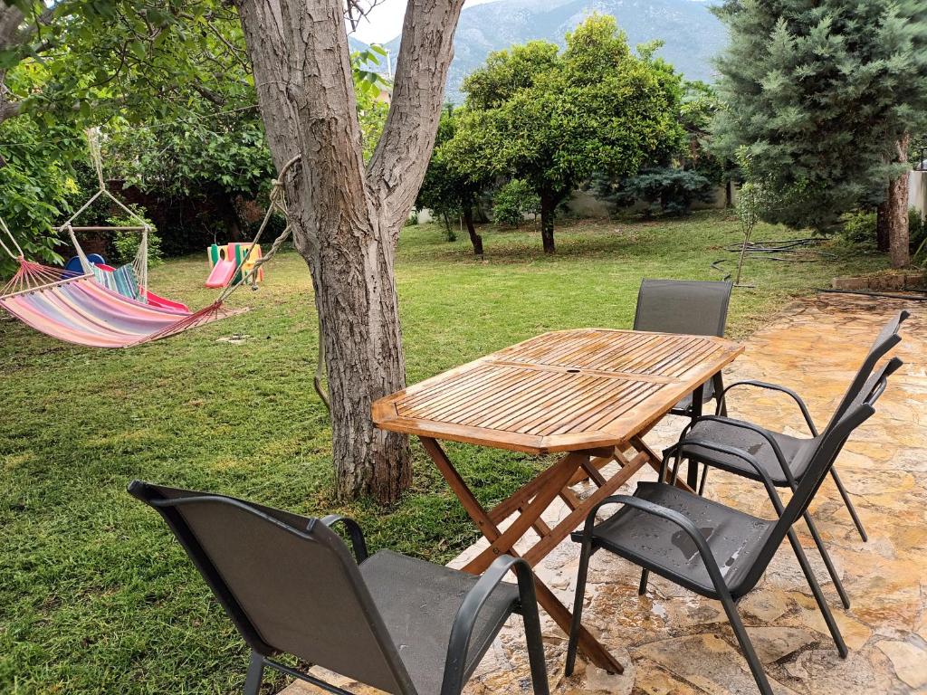un tavolo da picnic e sedie accanto a un albero di The Country House in Amarynthos a Yimnón