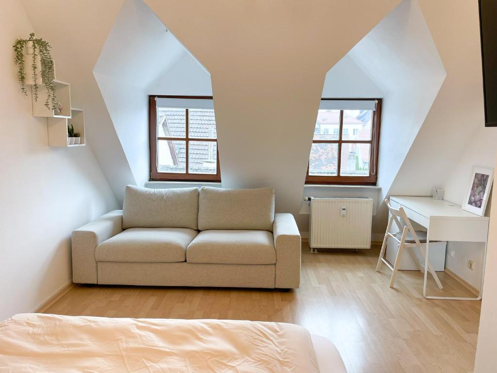 ein Wohnzimmer mit einem Sofa und einem Schreibtisch in der Unterkunft NAMI - ROBIN - Helle Apartments mitten in der Stadt in Memmingen