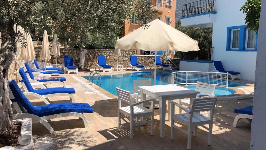 a swimming pool with blue chairs and a table and chairs at Lizo Hotel in Kalkan