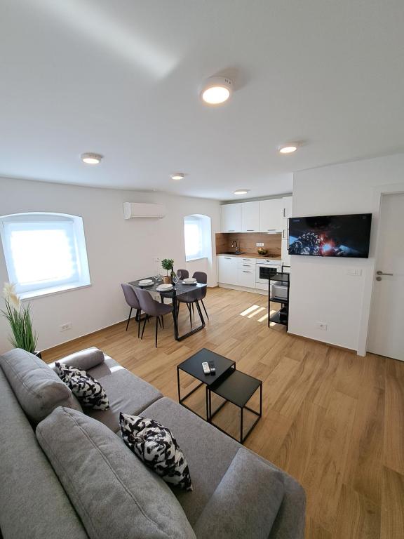 a living room with a couch and a table at Apartman Tea in Mali Lošinj