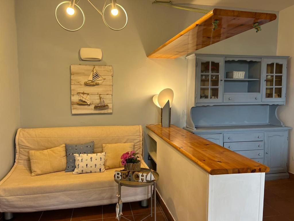 ein Wohnzimmer mit einem Sofa und einem Tisch in der Unterkunft Villa Zefiro - Campomarino di Maruggio in Campomarino