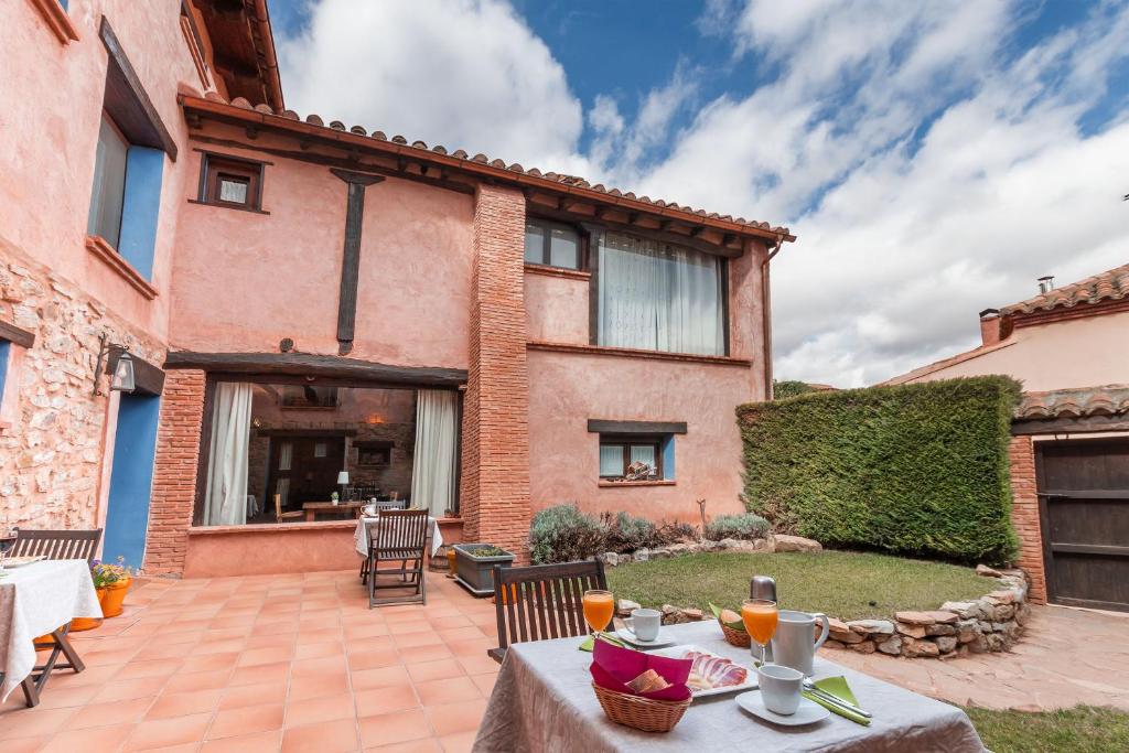 a patio with a table and chairs in front of a house at Casa Rural La Carretería in Camañas