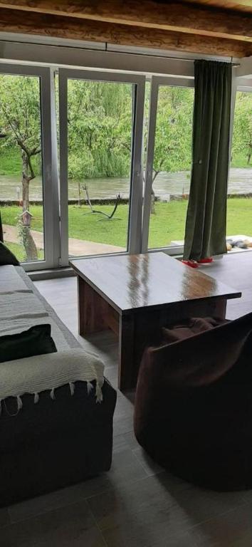 a living room with a table and a large window at Apartman Vrbas in Jajce