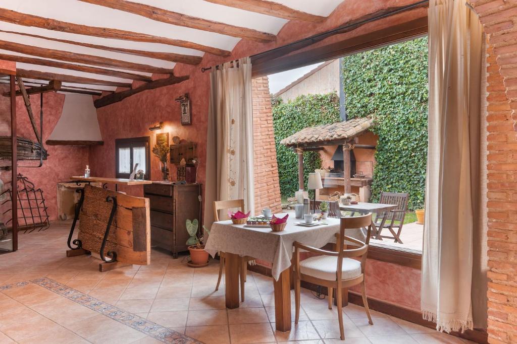 a kitchen and dining room with a table and a window at Casa Rural La Carretería in Camañas