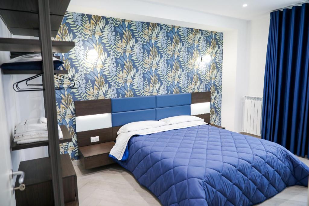 a bedroom with a blue bed and a blue and white wall at Palazzo Archeo in Pompei