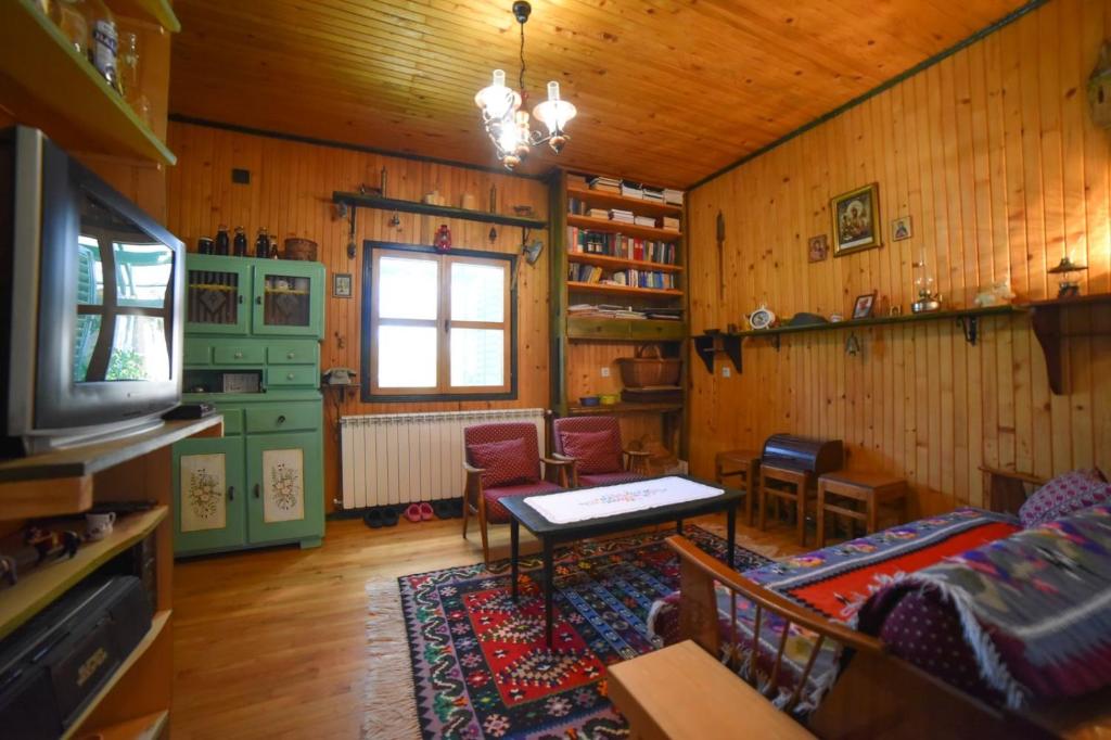 un soggiorno con divano, tavolo e TV di Medjedovica Brdo Godovik a Godovik