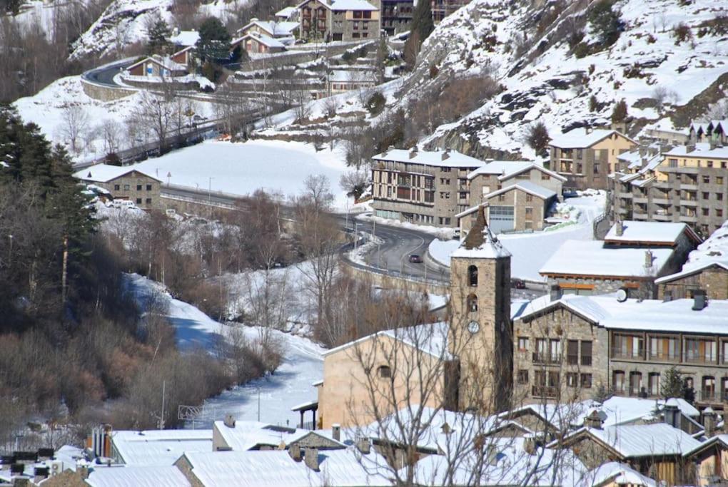 a small town with a clock tower in the snow at Appartement au coeur d'Ordino in Ordino