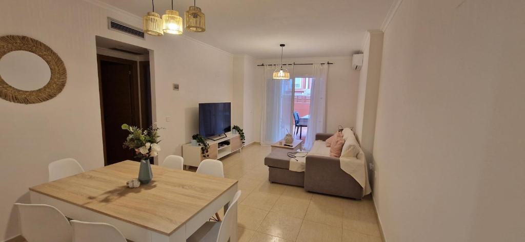 a living room with a table and a couch at Apartamento planta baja con piscina in Denia