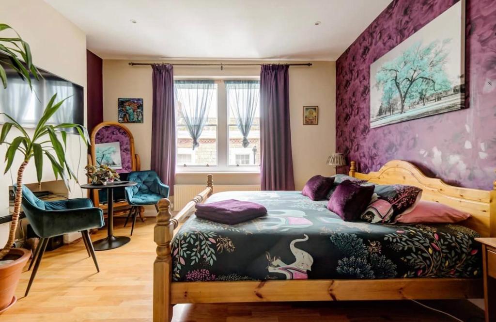 a bedroom with a bed and a purple wall at Stunning Super King, Close to Beach, Shared Bathroom in St. Leonards