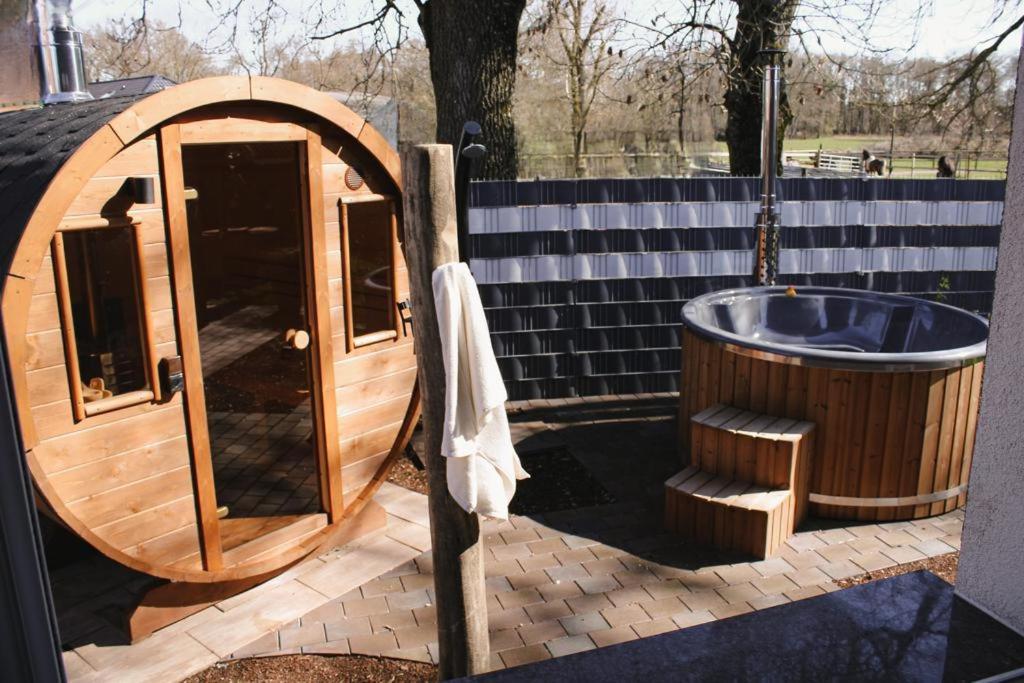 a wooden sauna with a tub and a towel at Marica‘s Meereszeiten Wellness in Midlum