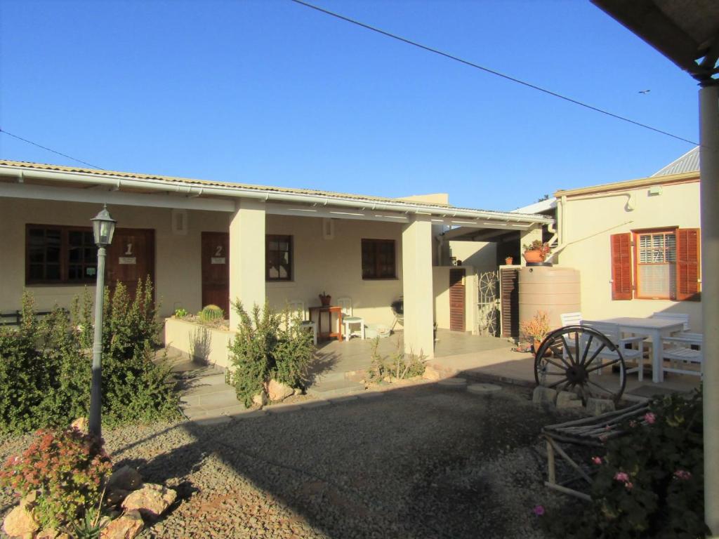 a white house with a wagon in front of it at De Wawielhuis in Calitzdorp