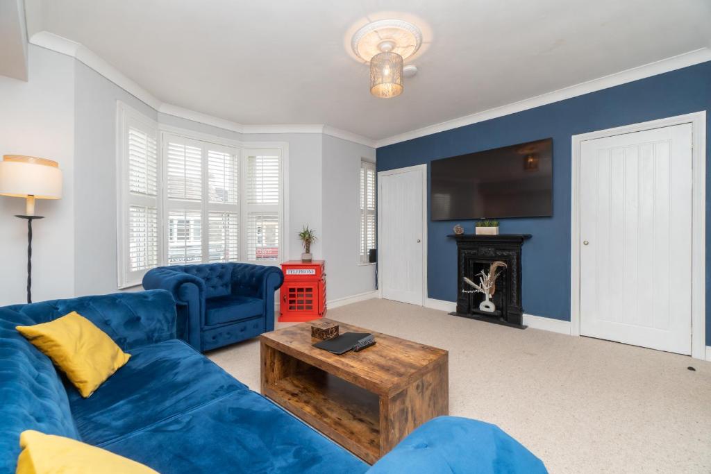 a living room with a blue couch and a fireplace at Modern Maisonette in Vibrant Bristol, Free Parking in Bristol