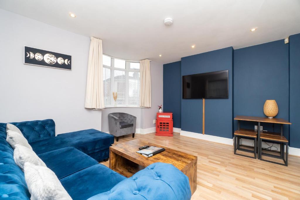 a living room with a blue couch and a tv at Spacious 2 bed Southville flat near Harbourside in Bristol