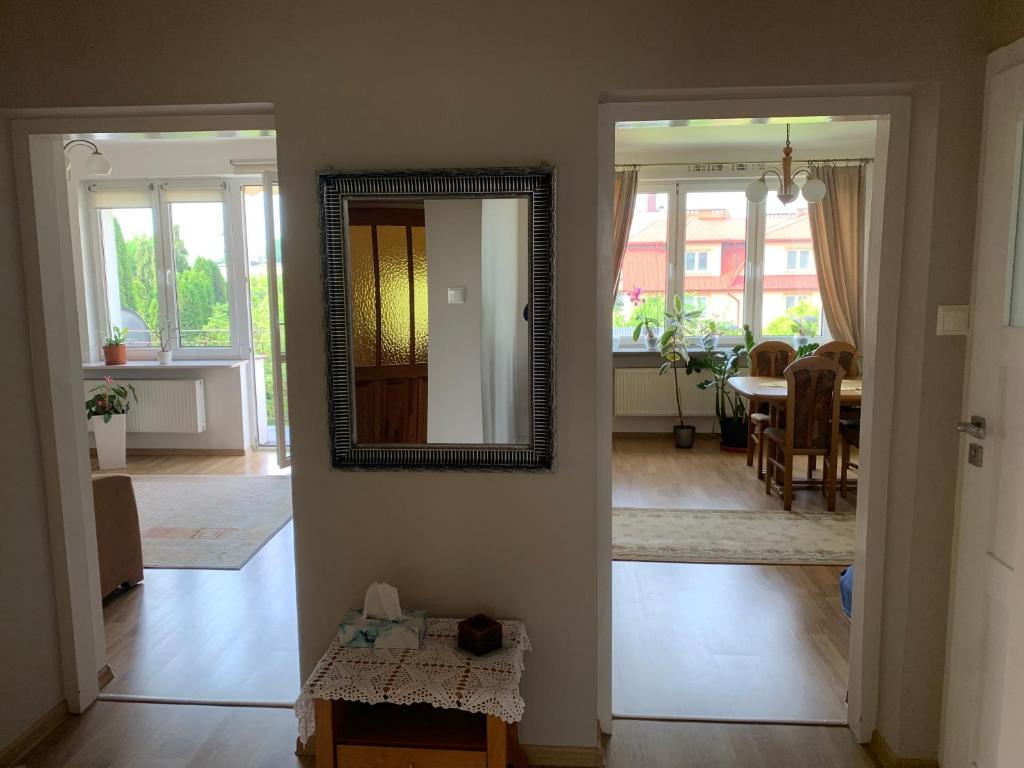 a hallway with a mirror and a dining room at Apartament z ogrodem Harcerska 4 in Zamość
