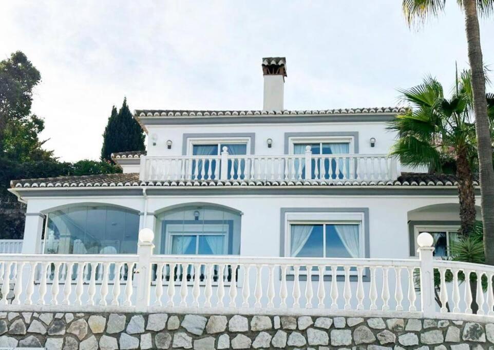 uma casa branca com uma cerca branca e palmeiras em Villa Torre Nueva, Mijas Costa em La Cala de Mijas