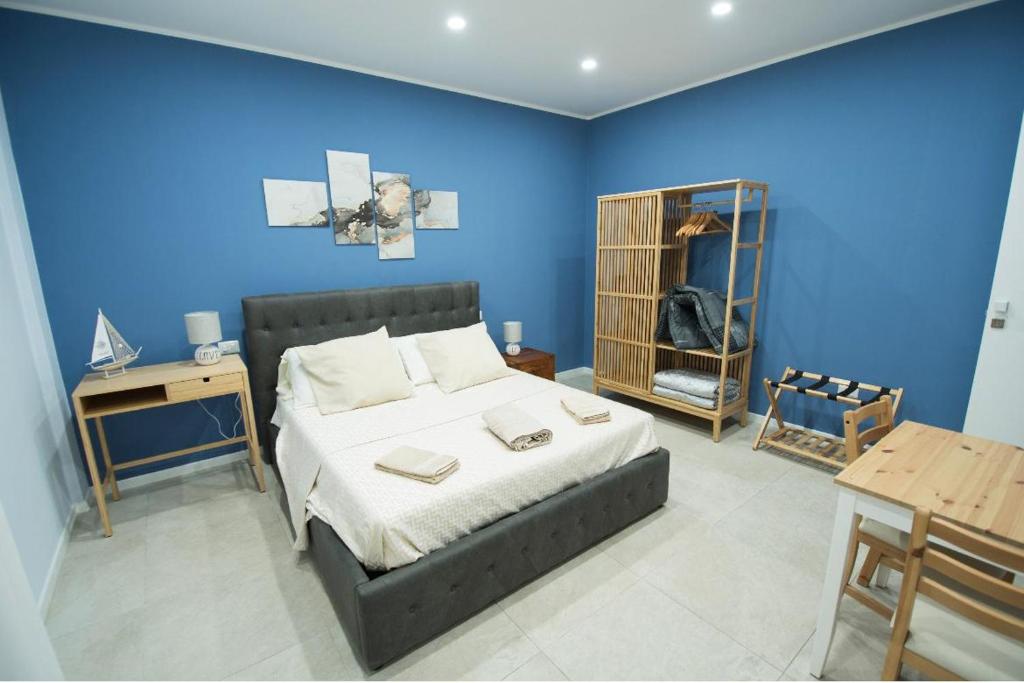 um quarto com uma cama e uma parede azul em Via Cino Cagliari em Cagliari
