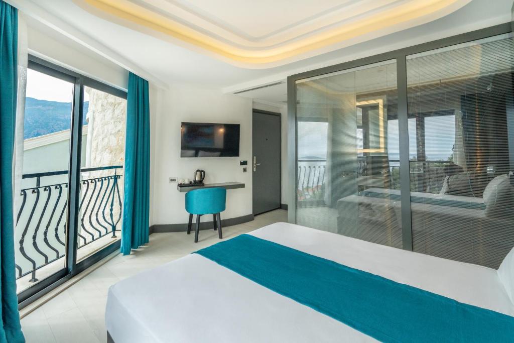 a bedroom with a bed and a balcony at Gümüş Yazar Hotel in Kaş