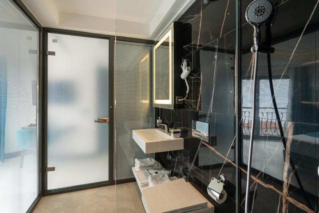 a bathroom with a sink and a shower at Gümüş Yazar Hotel in Kaş