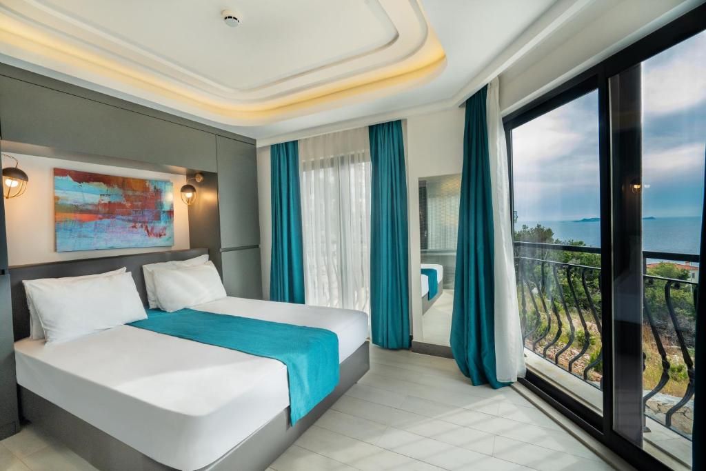 a bedroom with a bed and a balcony at Gümüş Yazar Hotel in Kaş