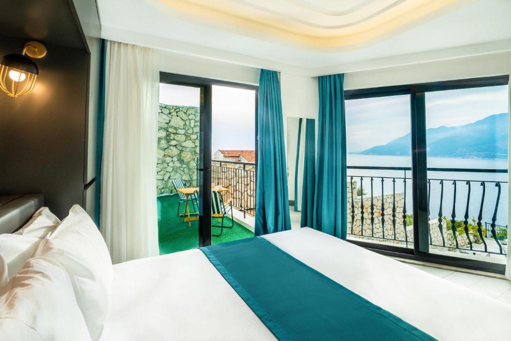 a hotel room with a bed and a view of the ocean at Gümüş Yazar Hotel in Kaş