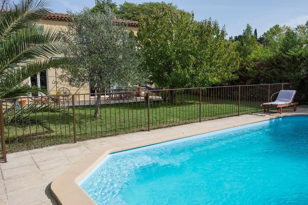 uma piscina em frente a uma cerca em Agréable villa avec jardin et piscine em Allauch