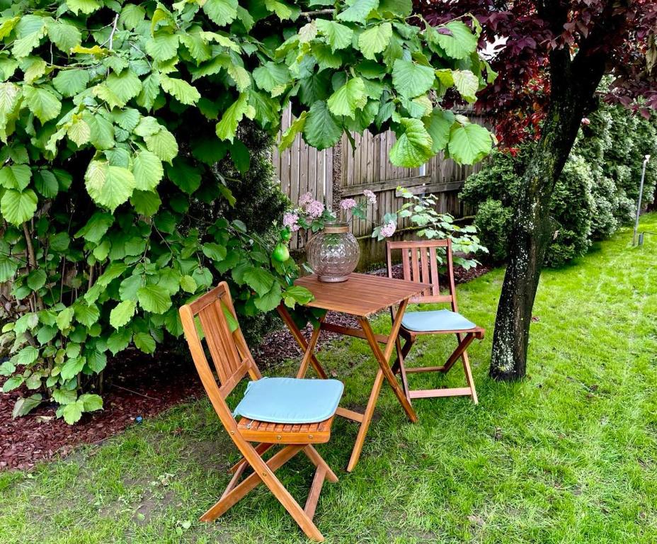 a wooden table and chairs in a yard at AKÁCIA APARTMAN in Nyíregyháza