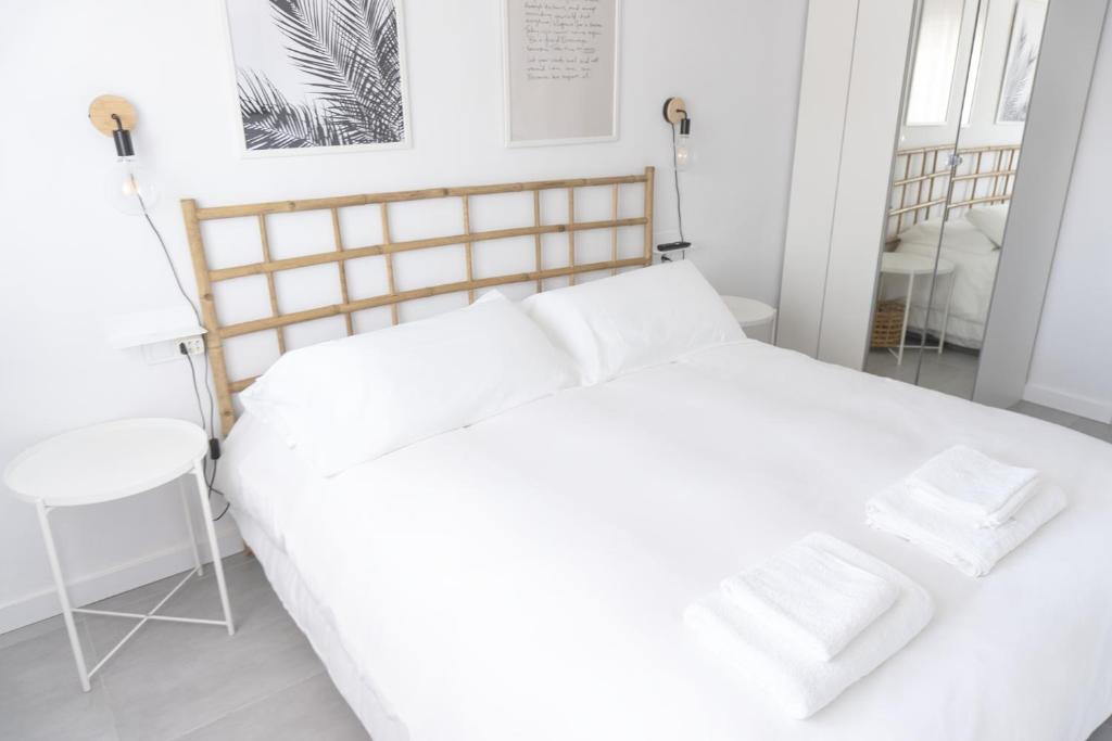 a bedroom with a white bed with two white towels at Apartamento con Parking a 50m de la playa in Sant Antoni de Calonge