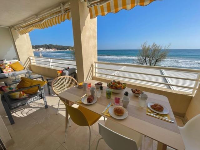 une table avec de la nourriture dessus avec vue sur l'océan dans l'établissement Les 2 Freres - Residence la fontaine Les Sablettes, à La Seyne-sur-Mer