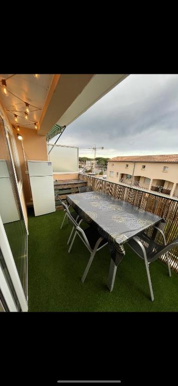 une table de pique-nique sur le balcon d'un immeuble dans l'établissement Appartement cosy - Cavalaire Sur Mer, à Cavalaire-sur-Mer