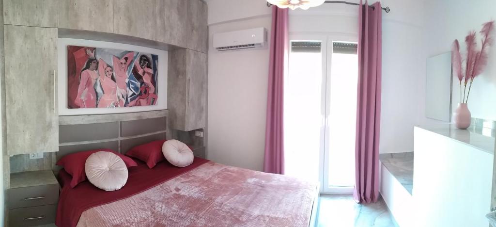 a bedroom with a bed with red sheets and pillows at Luxurious Maisonettes Nina & Tomas in Sivota in Sivota