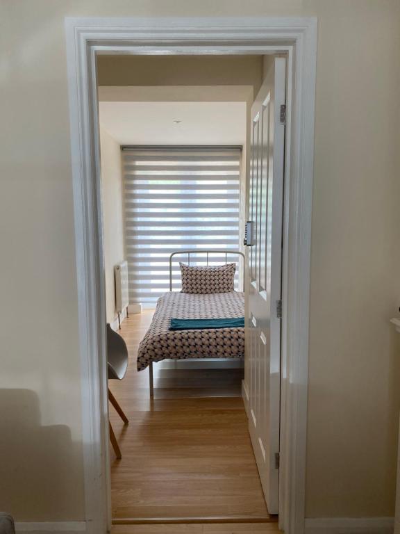 um corredor com uma cama num quarto com uma janela em Single Room only for one adult em Southall