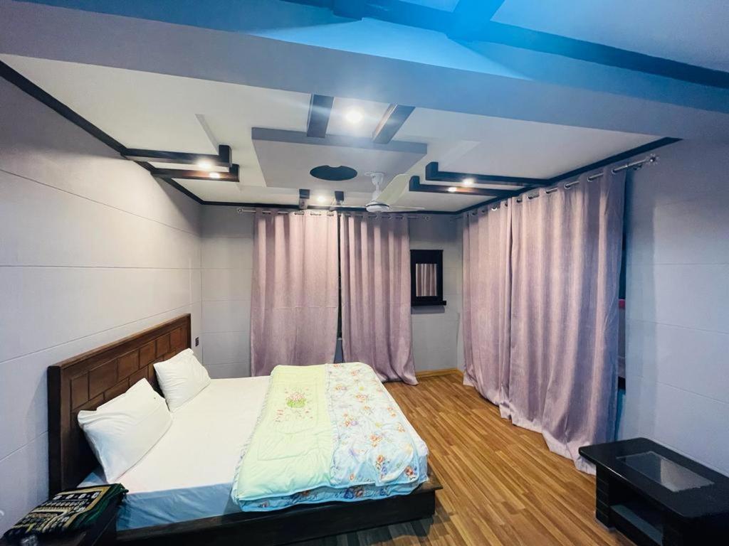 a bedroom with a bed and a blue ceiling at Royal Resort Skardu in Skardu