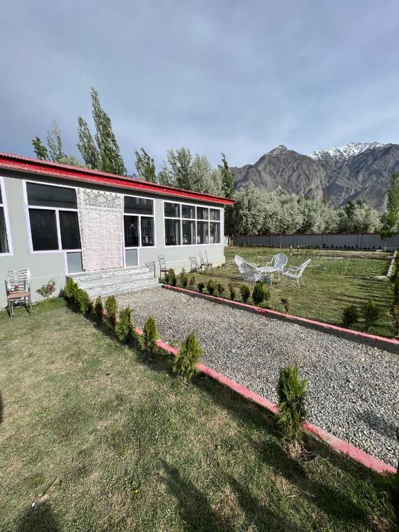 a house with a garden and chairs in front of it at Royal Resort Skardu in Skardu
