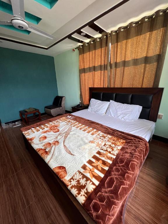 a bedroom with a large bed with a comforter on it at Royal Resort Skardu in Skardu