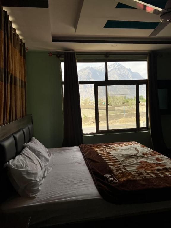 a bedroom with a bed with a large window at Royal Resort Skardu in Skardu