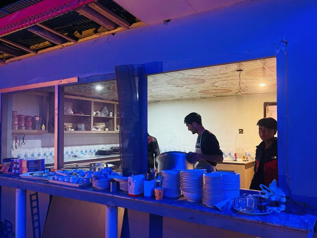 two men standing in a kitchen preparing food at Royal Resort Skardu in Skardu