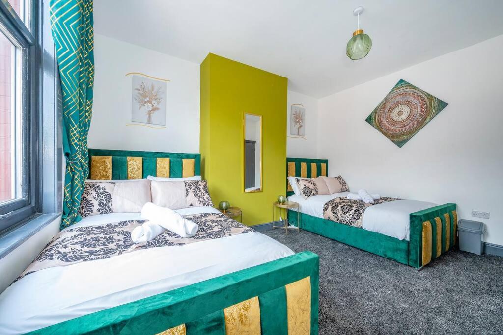 two beds in a room with yellow and green at *15w* setup for your most amazing & relaxed stay + Free Parking + Free Fast WiFi * in Beeston Hill