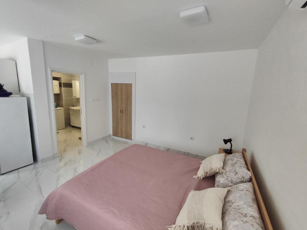 una camera da letto con un grande letto in una stanza bianca di Studio Apartment Klarić a Drivenik