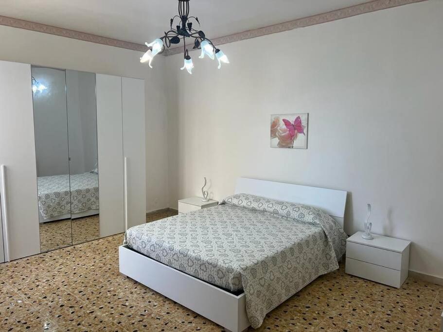 een witte slaapkamer met een bed en een spiegel bij Augusta Apartment - SR in Augusta