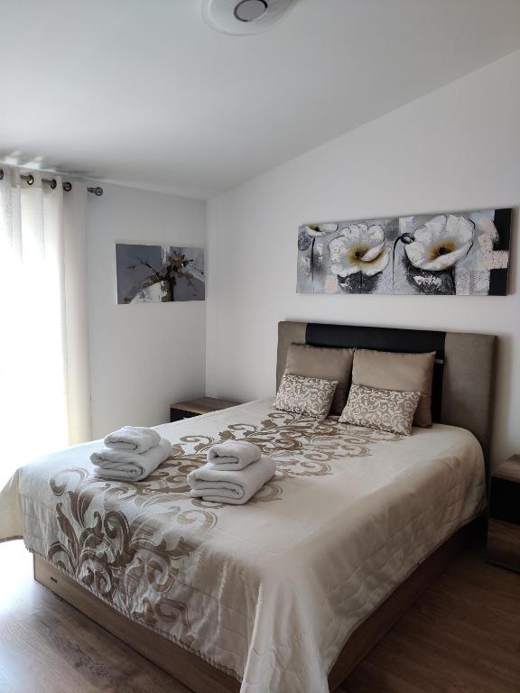 ein weißes Schlafzimmer mit einem großen Bett mit Handtüchern darauf in der Unterkunft Casinha Gabriela in Lagos