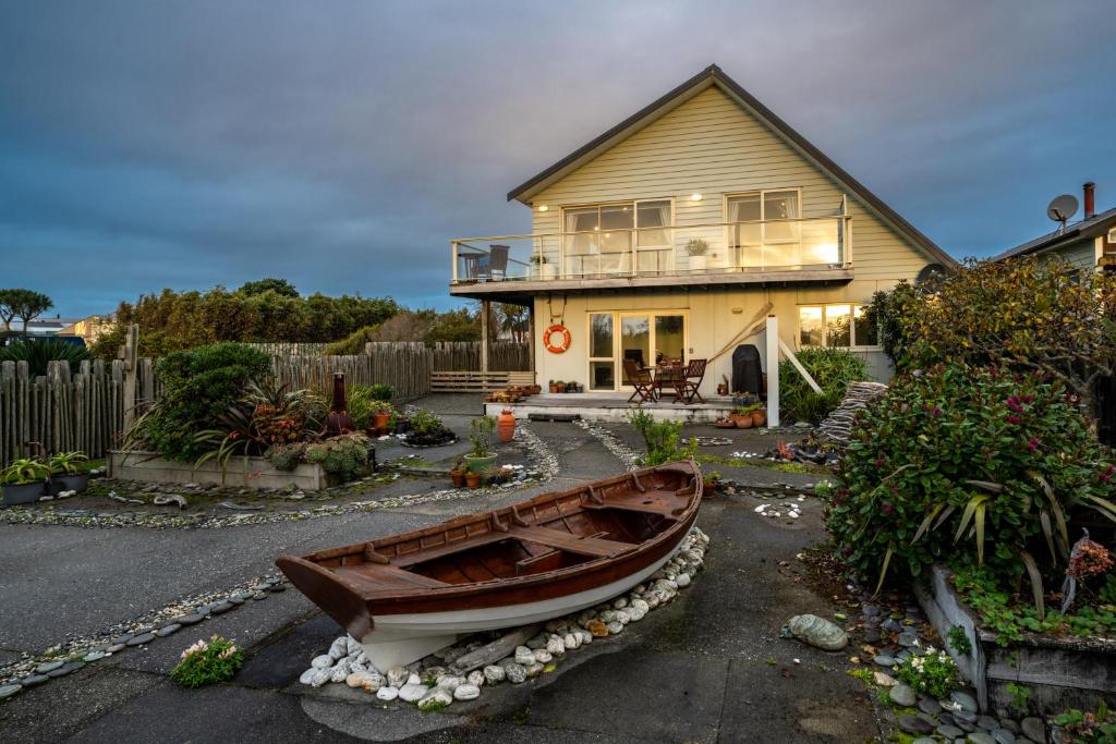 a small boat in the yard of a house at Beachside Apartment in Hokitika