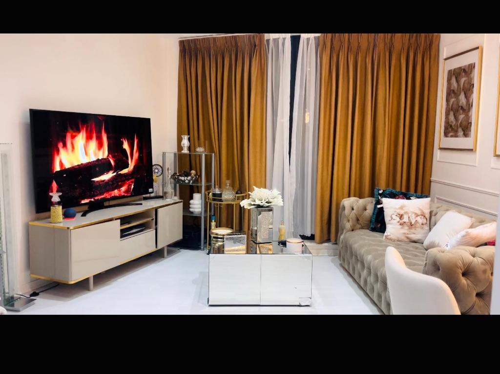 - un salon avec un canapé et une télévision avec une cheminée dans l'établissement Spacious one bedroom ft in Central London King’s Cross, à Londres