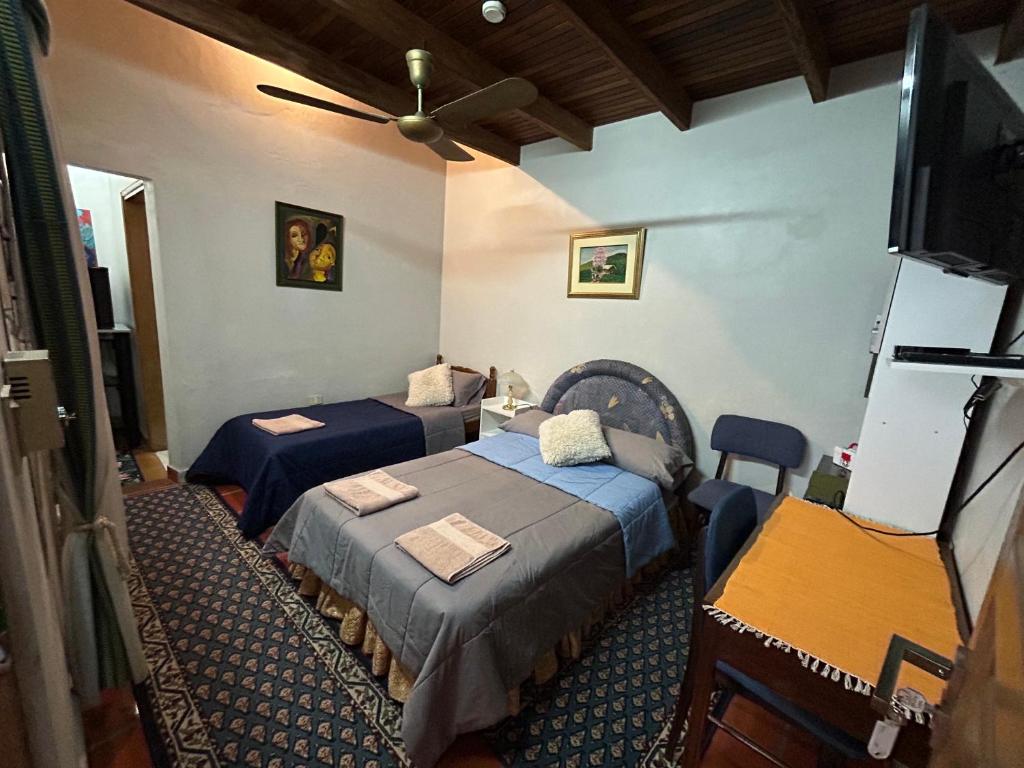 a room with two beds and a television in it at Habitación en suite, Excelente Ubicación in Asunción