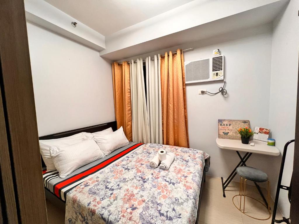 a small bedroom with a bed and a desk at Yam Staycation Shore Residences in Manila