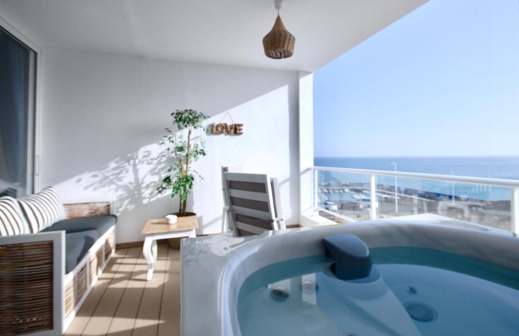 Habitación con bañera de hidromasaje y balcón con vistas al océano. en Marine Lovers - Jacuzzi Fuerteventura en Gran Tarajal