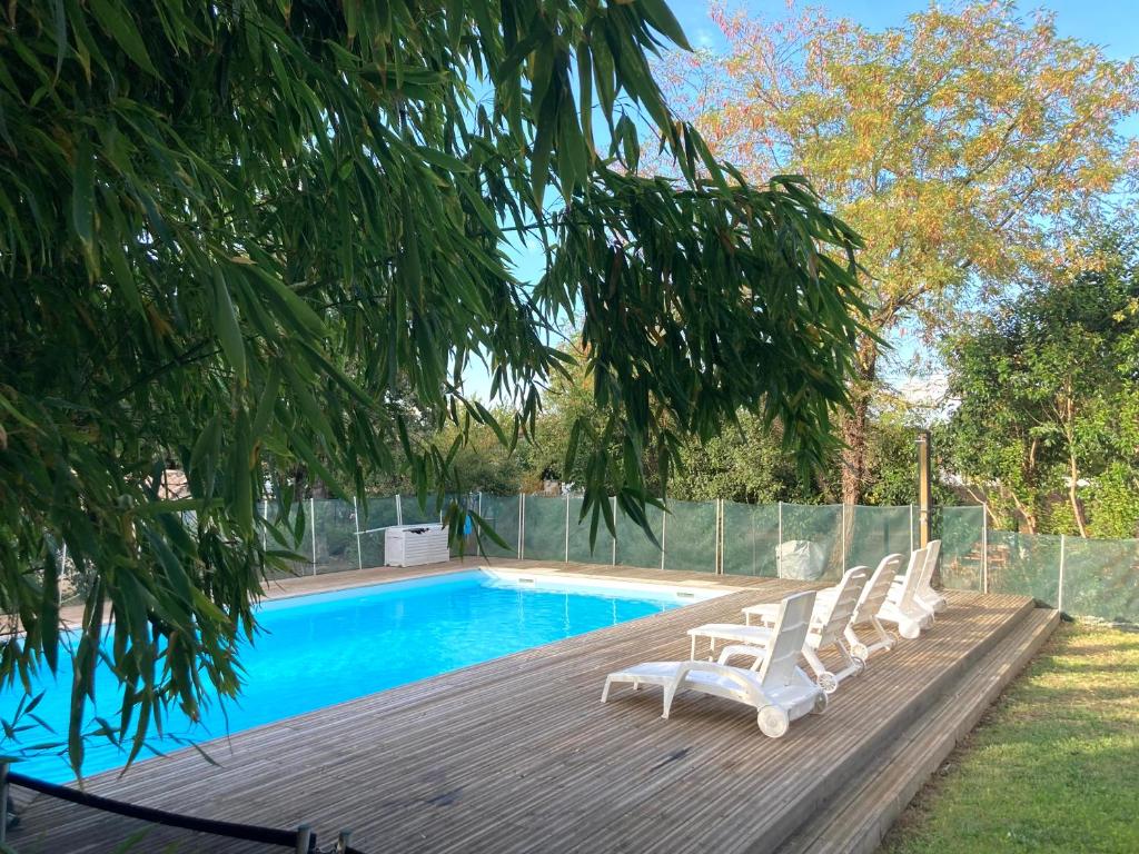 - un groupe de chaises assises sur une terrasse à côté d'une piscine dans l'établissement Résidence Thibaud, à Toulouse